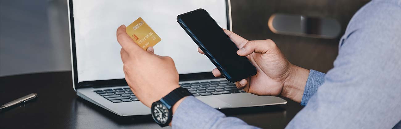 holding up credit card to a handheld device Page Banner 