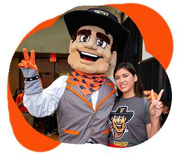 Student and Vaquero mascot with Vs up.