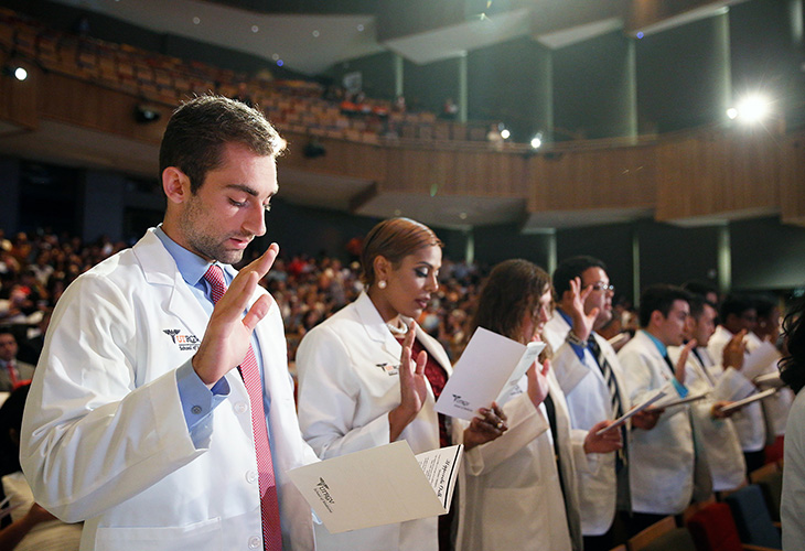 Medical students reading oath during white coat ceremony