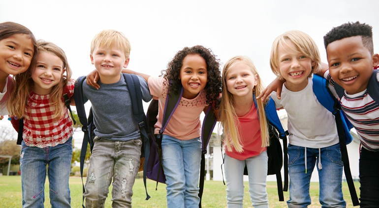 Diverse group of children wearing backpacks