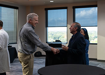 two faculty members speaking with each other