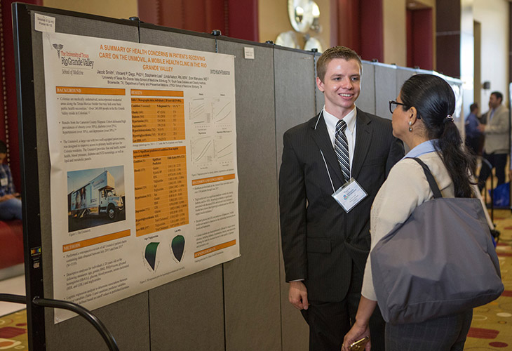 Image of UTRGV medical student in suit presenting research to physician at conference Page Banner 