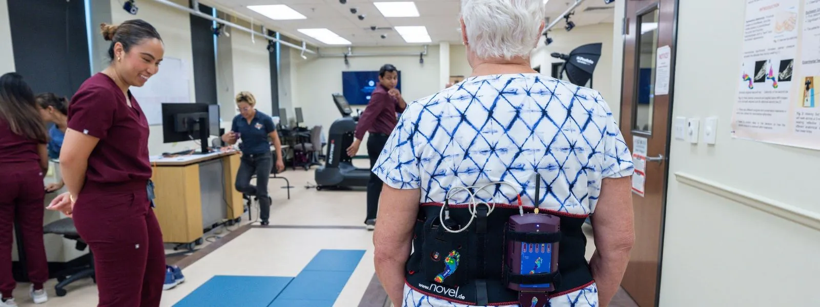 SOPM student assisting elderly patient.