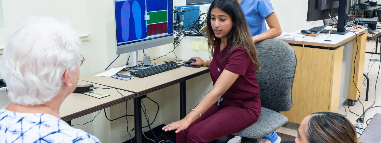 SOPM student guiding patient with hand.