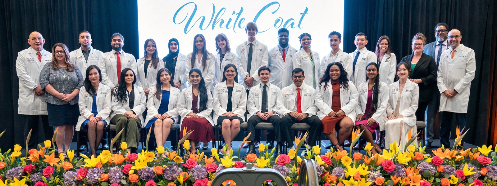UTRGV SOPM students pose onstage for a group photo during the White Coat Ceremony.
