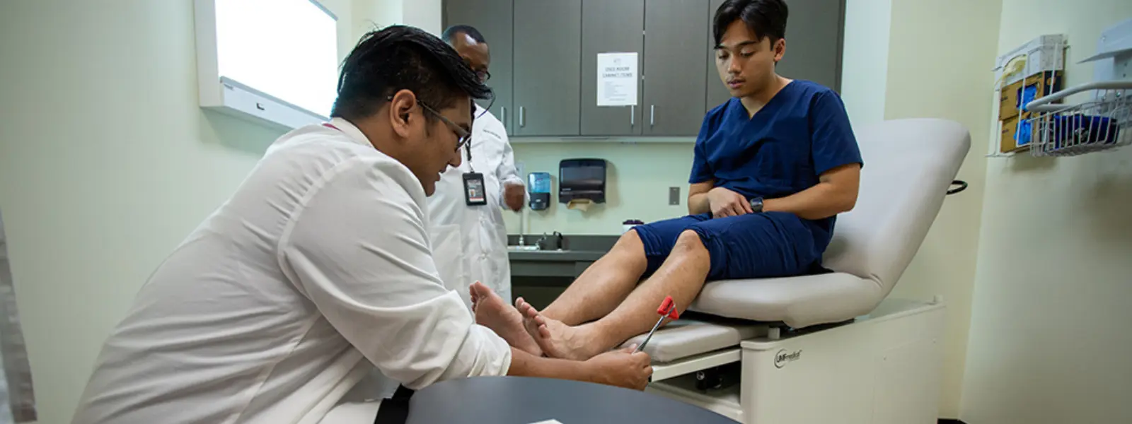 Doctor looking at patient's feet during consultation.