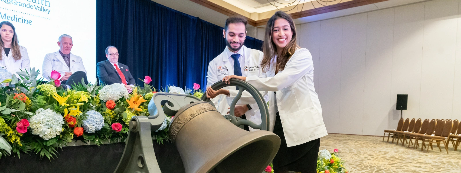 Students ringing bell during ceremony.
