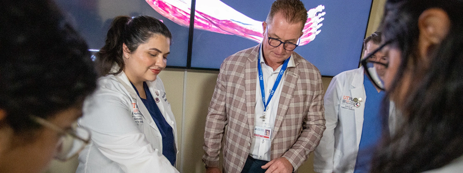 A faculty member and an SOPM student collaborate using a digital screen table.