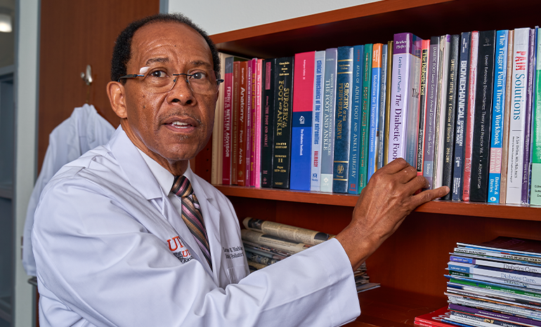 Lawrence B. Harkless, DPM standing in front of a bookshelf