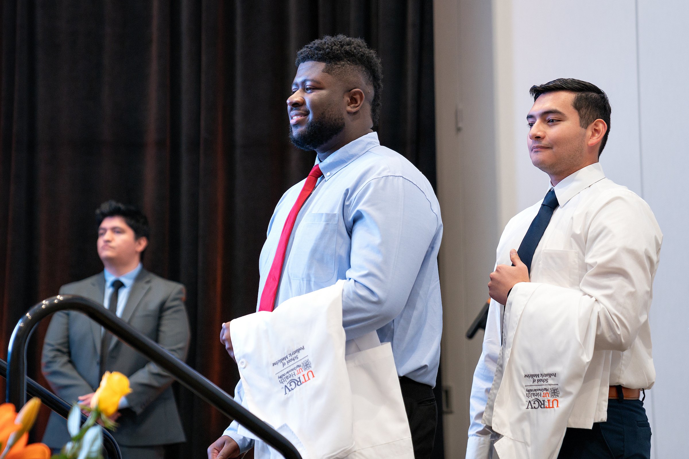 SOPM students on stage during White Coat Ceremony.