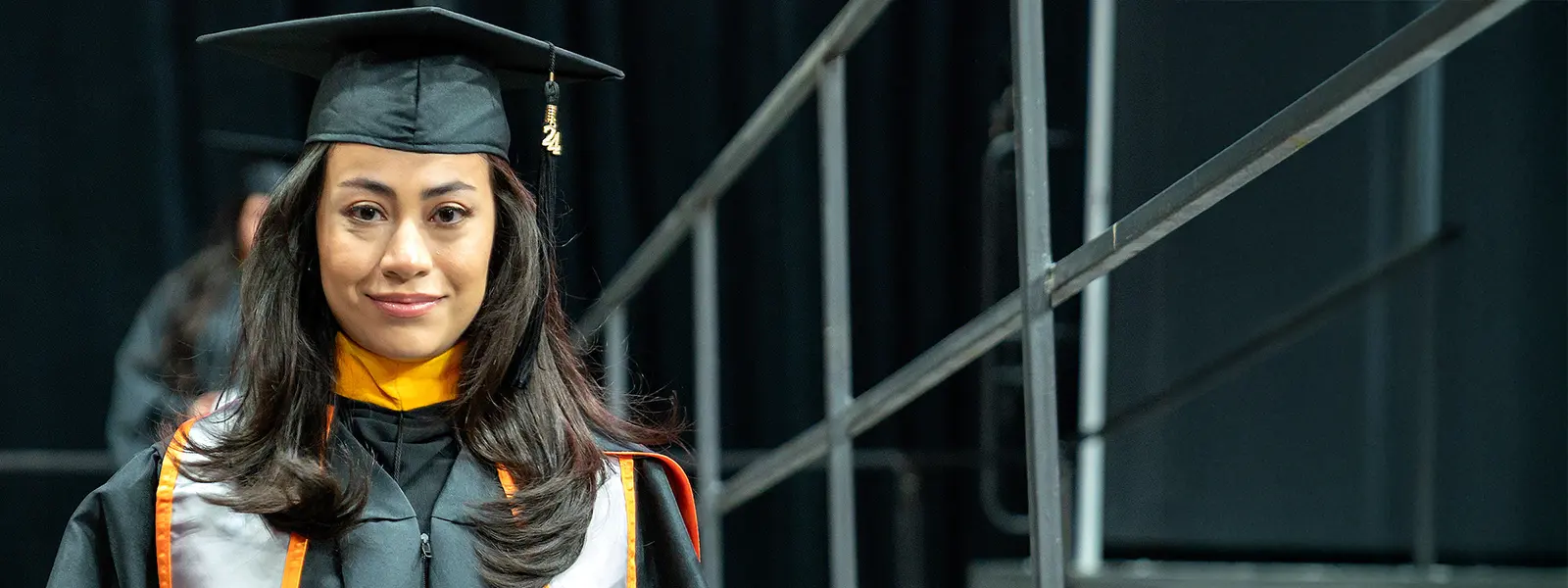 graduate walking off stage after recieving her diplopma