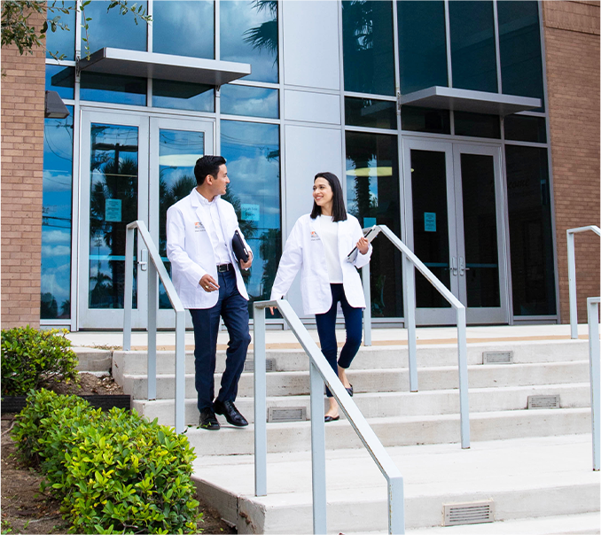 UTRGV medical students walking on campus while wearing white lab coats