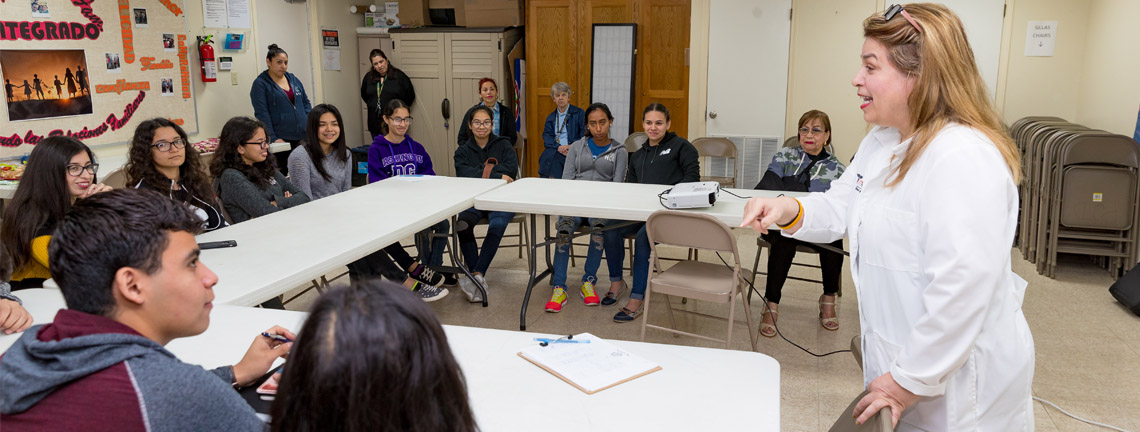 Dr. Gladys Maestre (standing, at right), a UTRGV professor of neuroscience and human genetics and director of the UTRGV Alzheimer´s Disease Resource Center for Minority Aging Research, is seen here working with a group of high school students known as the center’s Alzheimer’s Ambassadors. The center provides education, mentoring and support for the ambassadors, Maestre said, so they can go to events and into the community to become the voice of people with Alzheimer’s and their caregivers. (UTRGV Photo by David Pike)