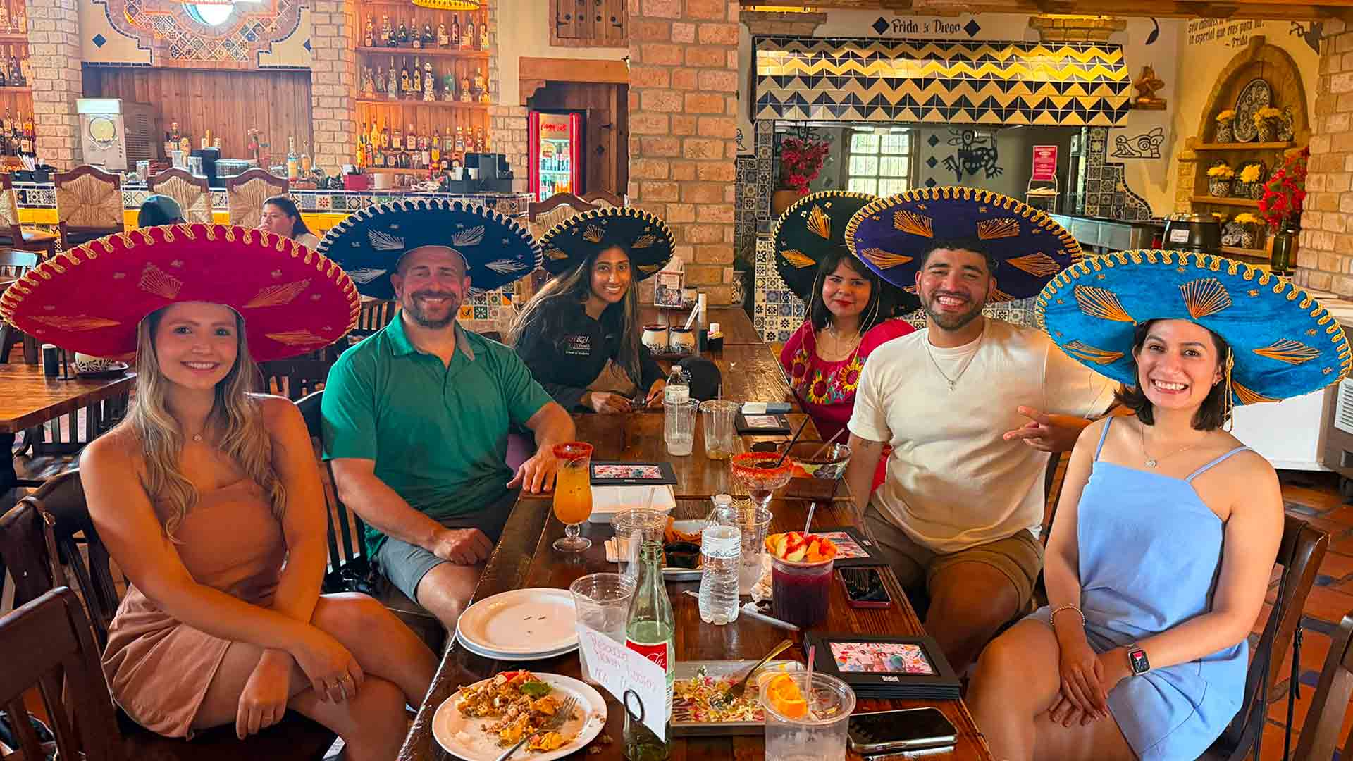 Residents share a meal while wearing sombreros during a residency program social activity.