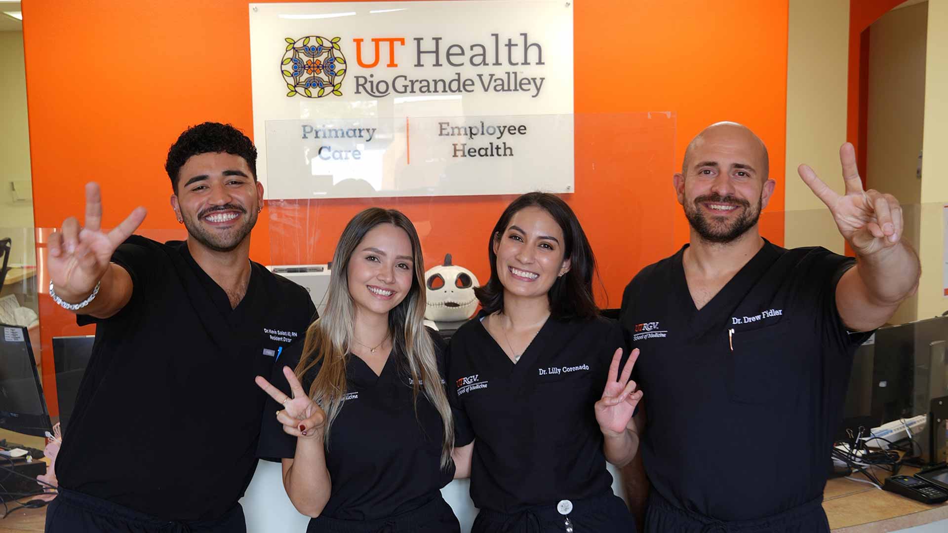 UTRGV residents in scrubs pose together at a UT Health Rio Grande Valley primary care clinic.