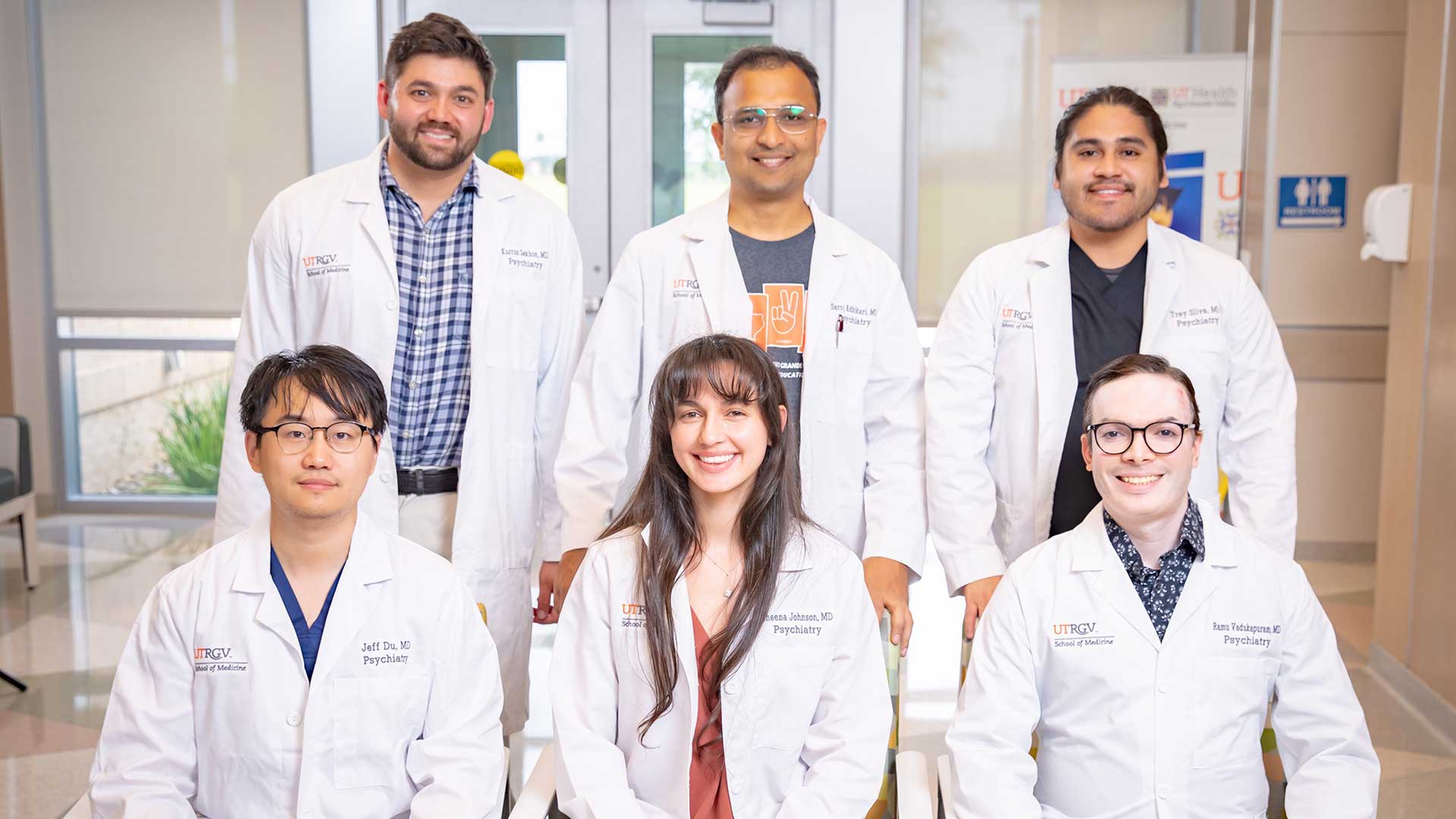 A group photo of six medical professionals in white coats
