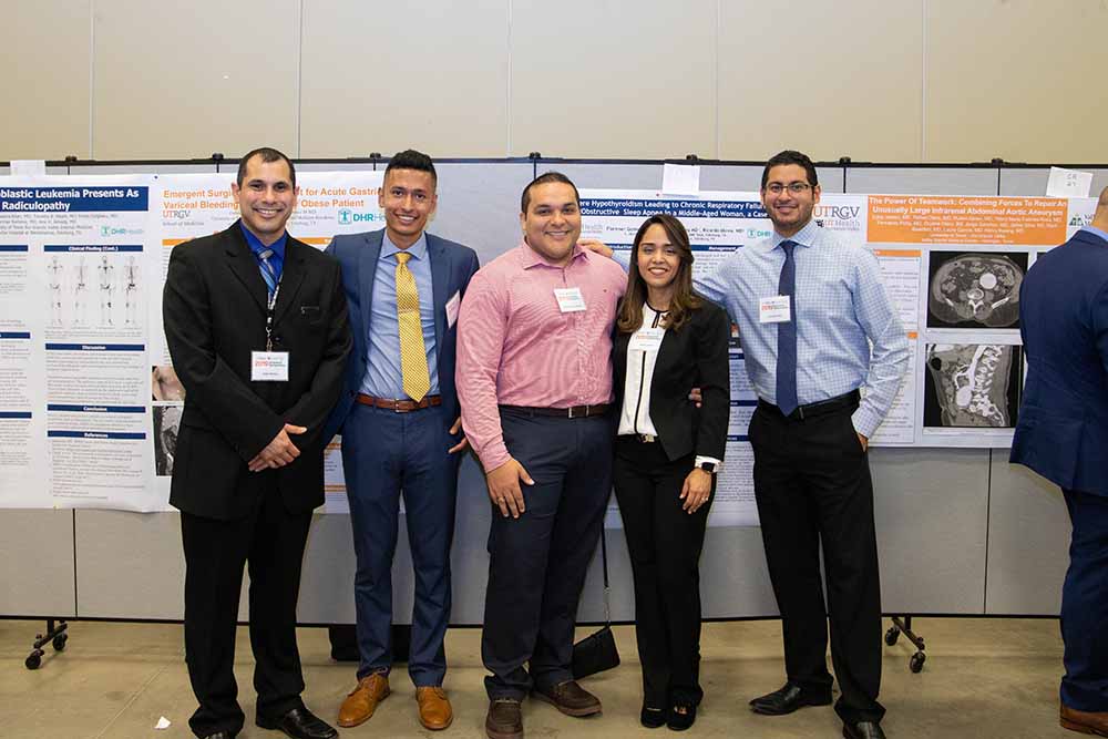 Five people standing in front of research posters