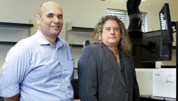 Dr. Mathew Posing in front of lab equipment