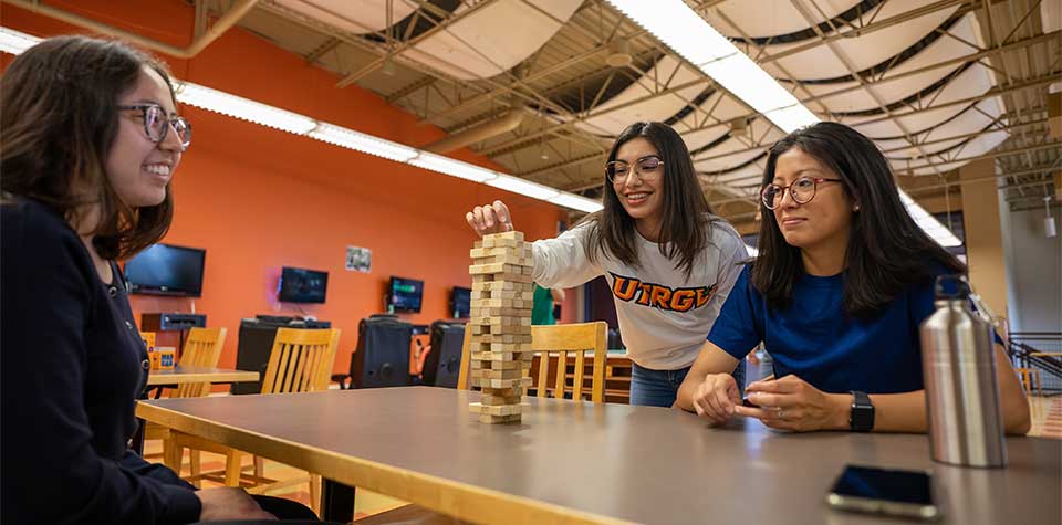 three students playing  Jenga at the Student Union