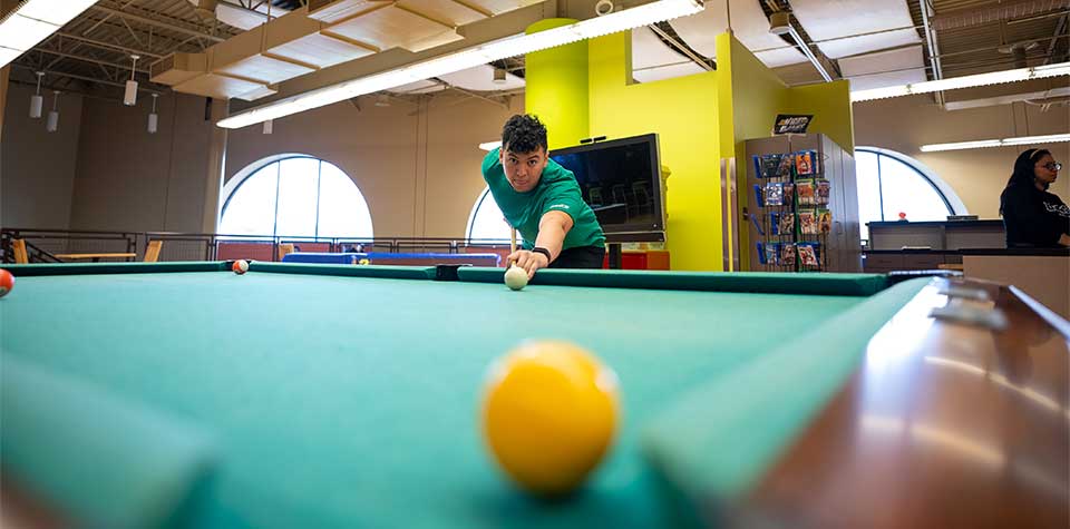 Student playing pool at the Student Union