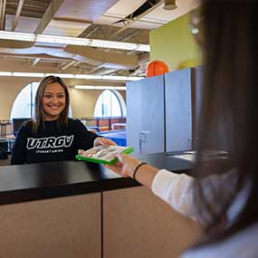 staff handing a video game disk to student