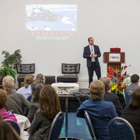 a picture of a person giving a talk at the T.R.A.C.K.S event and the people listening