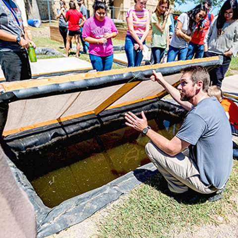 picture of dr. gabler explaining one of the aquaculture ponds on UTRGV Brownsville's Bella Casa C.R.A.W.F.I.S.H. garden