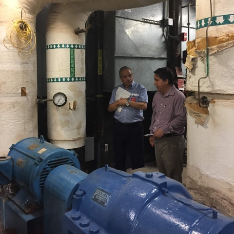 photo of men discussing in from of a big blue pipe for the demand response feasible study hosted by UTRGV