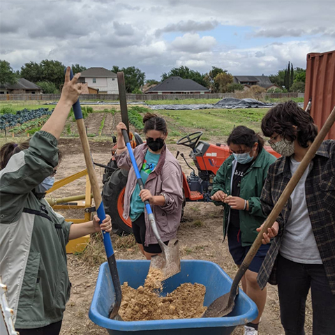 people adding mushroom substrate to compost and mulch piles at the hub of prosperity urban farm