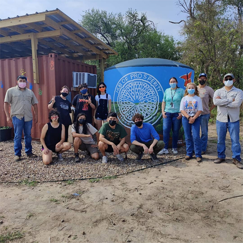 Sustainable Agriculture class in front of the hub of prosperity's new rainwater tank mural