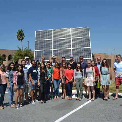 a picture of students, faculty, and staff standing in front of the solar arrays