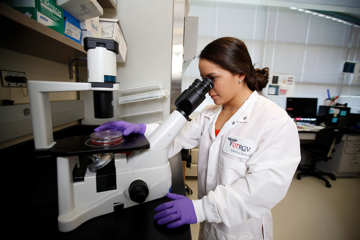 student looking into a microscope