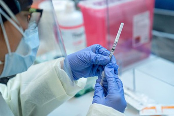 Picture of someone holding a vaccine needle