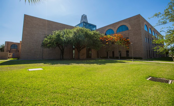 trees and grass in front of a UTRGV building