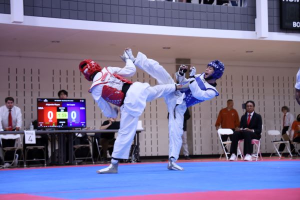 Alejandro Rayas (red) and Ian Lopez (blue) exchange attacks in the semifinals of the NCTA National Collegiate Sparring and Poomsae Team Trials. (Courtesy Photo)