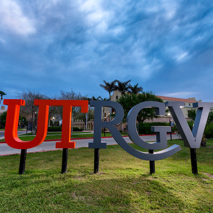 3 females holding up a big welcome sign for the T.R.A.C.K.S convention that UTRGV hosted a couple years ago and on it is the tracks logo, the name of the university, and sustainability words with the word sustainability being in the middle and the biggest in color green