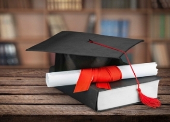 Graduation cap, book, and diploma.