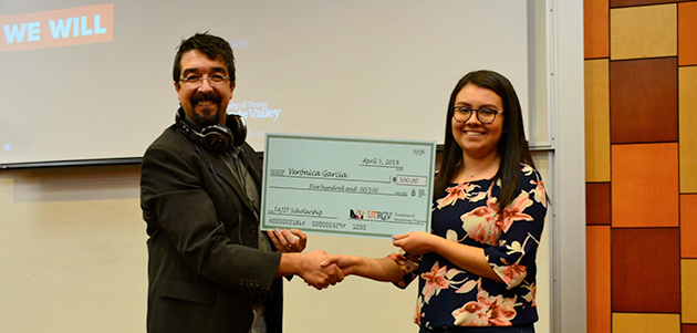 Translation and Interpreting Programs student accepts scholarship check