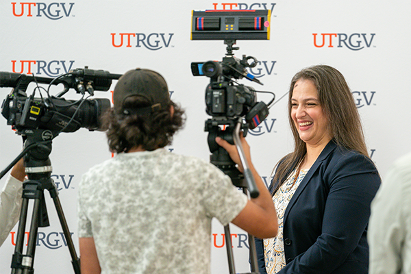 Photo of a press conference with a UTRGV employee being interviewed.