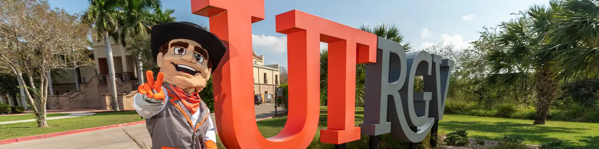 UTRGV mascot next to UTRGV sign