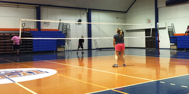 Students playing indoor volleyball